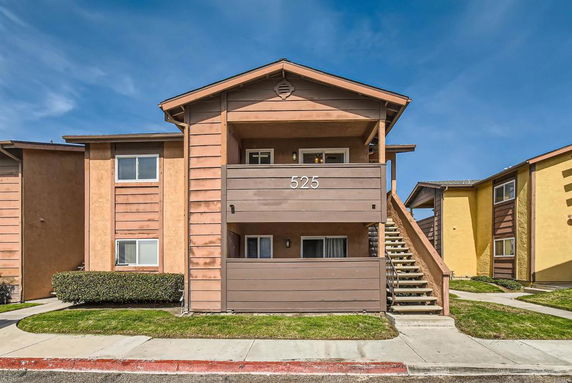 Front view of a two-story residential building with exterior stairs.