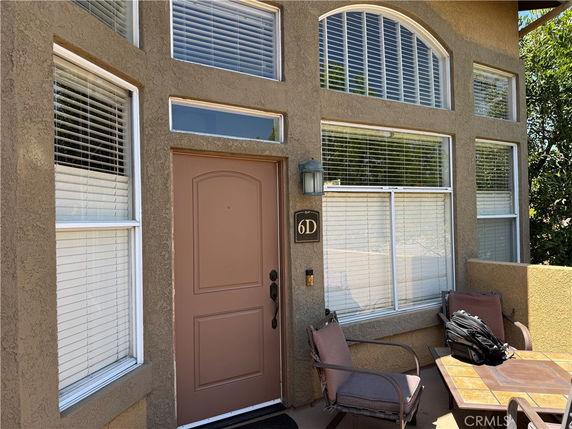 Front view of a house with multiple windows and a brown door.
