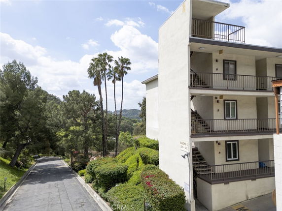 Side view of a three-story apartment building with balconies.