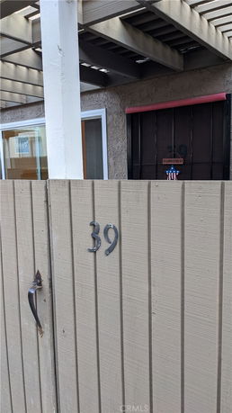 Front view of a house entrance with a numbered gate and door.