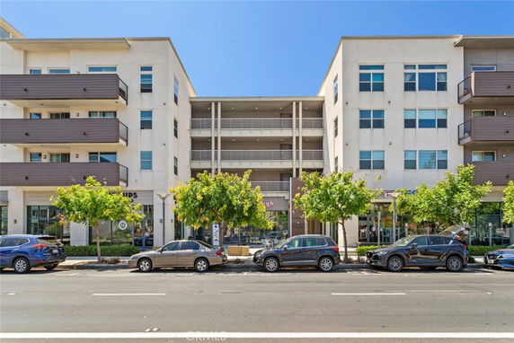 Front view of a modern multi-story apartment building with balconies.