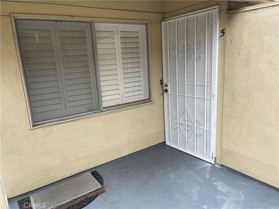 View of a residence with a security door and window shutters.