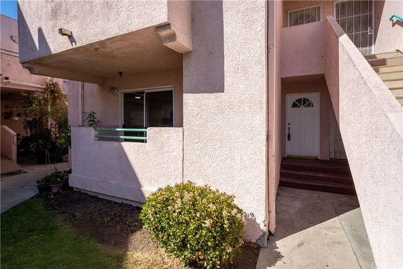 Front view of a two-story building with entrance stairs and a small balcony.