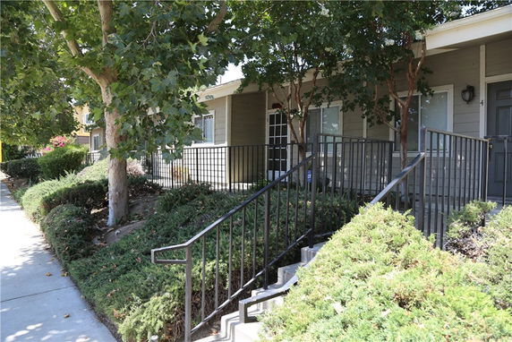 Front view of a residential building with stairs and railings.