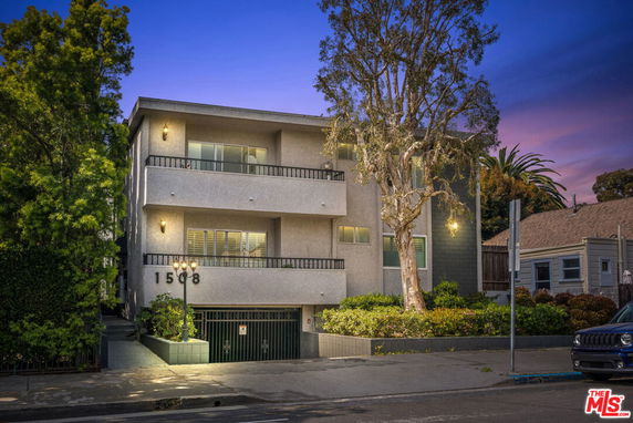 Front view of a modern three-story apartment building with balconies.