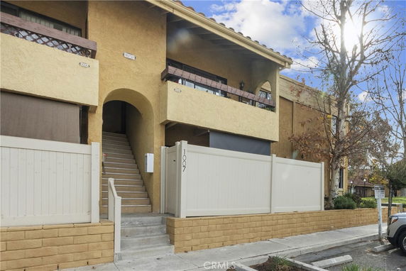 Front view of a two-story building with stairs leading to the entrance.