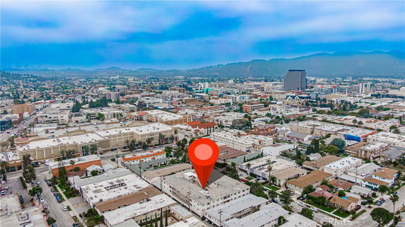 Aerial panoramic view of a city with multiple buildings and a prominent marker.