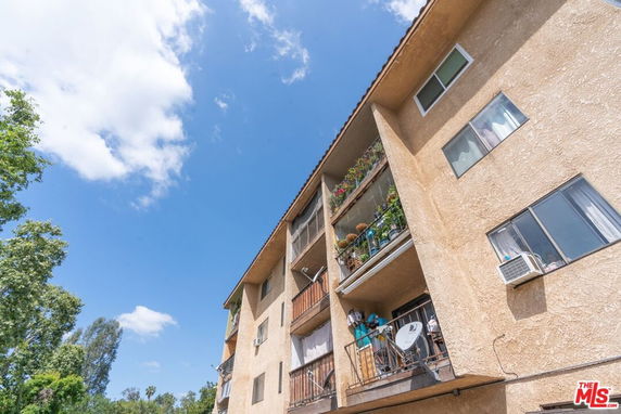 Front view of a multi-story apartment building with balconies.