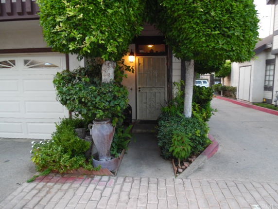 Front view of a house entrance with a small garden and garage door.