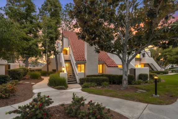 Front view of a two-story building with external stairs and a red tiled roof.