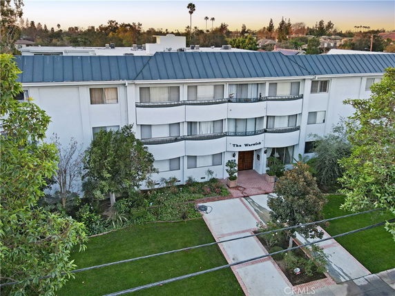 Front view of a three-story apartment building with balconies.