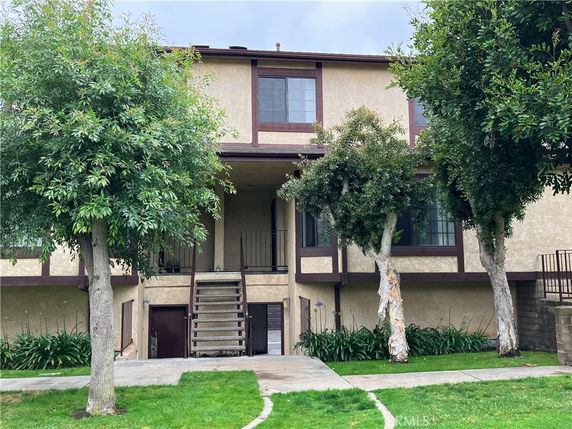 Front view of a two-story house with external staircase.