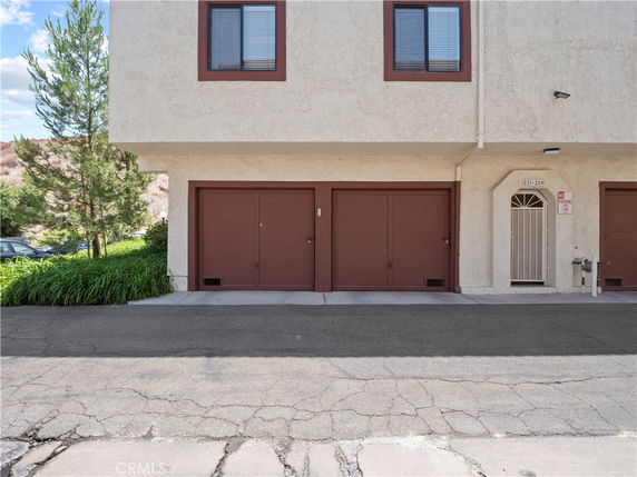 Front view of a building with a double garage and two windows above.