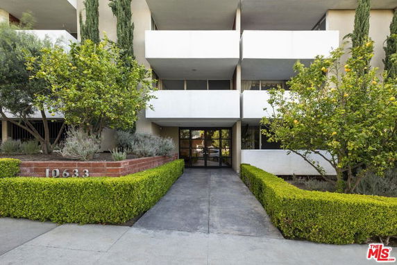 Front view of a multi-story building with balconies and entrance.