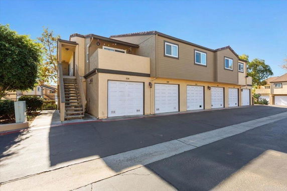 Front view of a two-story building with multiple garages on the ground floor.