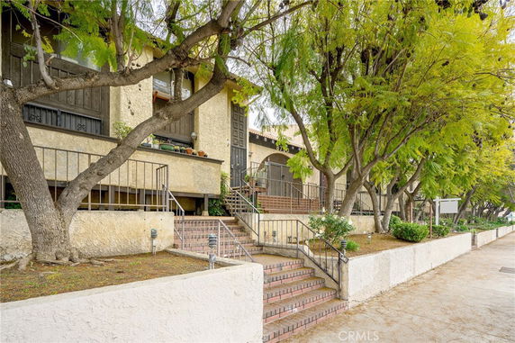 Front view of a two-story building with stairs leading to the entrance.