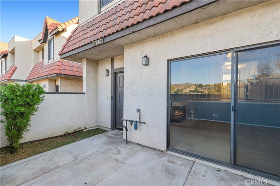 Front view of a house with a sliding glass door and tiled roof.