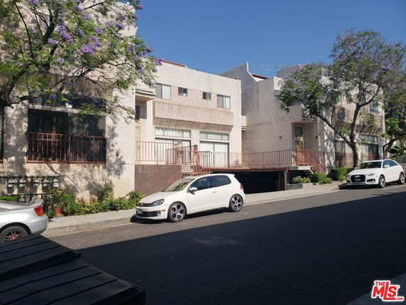 Front view of a multi-story building with parking area.