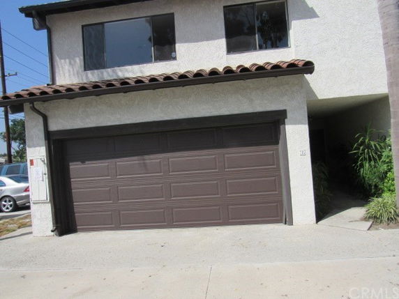Front view of a house with a brown double garage and tiled roof.
