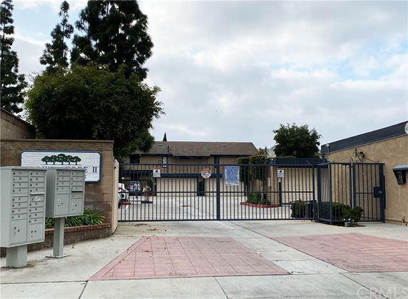 Front view of a gated residential complex with a central driveway.