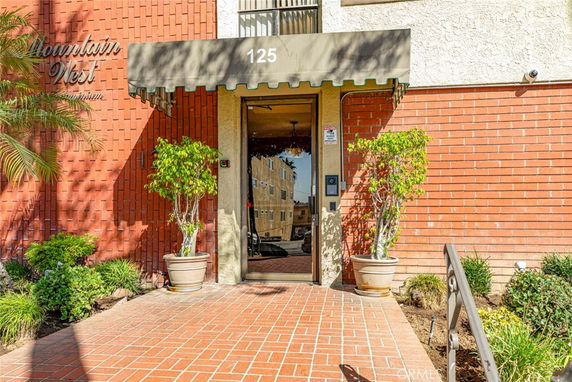 Front view of a building entrance with a brick facade and an awning.