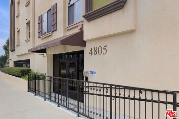 Front view of a multi-story building with gated entrance.