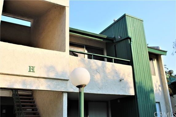 Front view of a multi-story apartment building with a green facade.