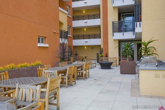 Outdoor recreational area with tables and chairs in a building complex.