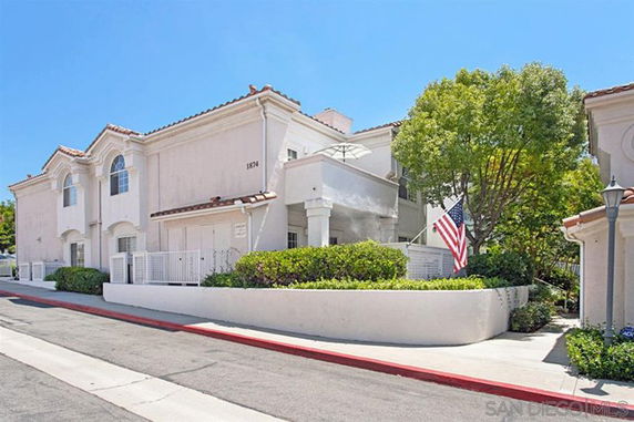 Front view of a two-story residential building with white exterior and arched windows.