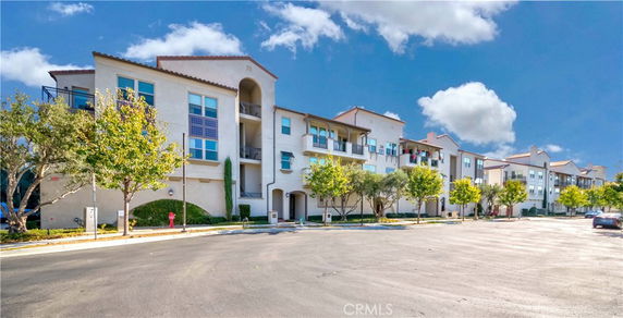 Front view of a multi-story residential building with balconies.