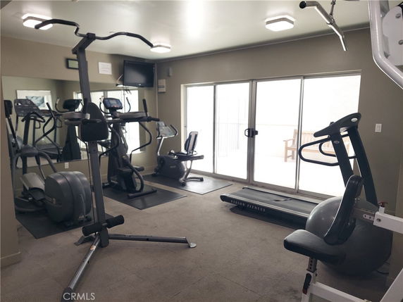Indoor gym area with exercise equipment and large windows.