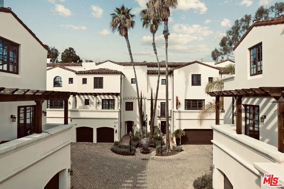 Front view of a multi-story building complex with white exterior and red-tiled roofs.