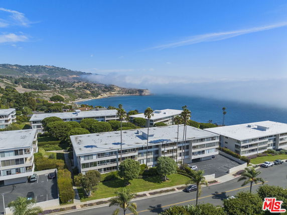 Panoramic view of buildings overlooking the ocean and coastal hills.