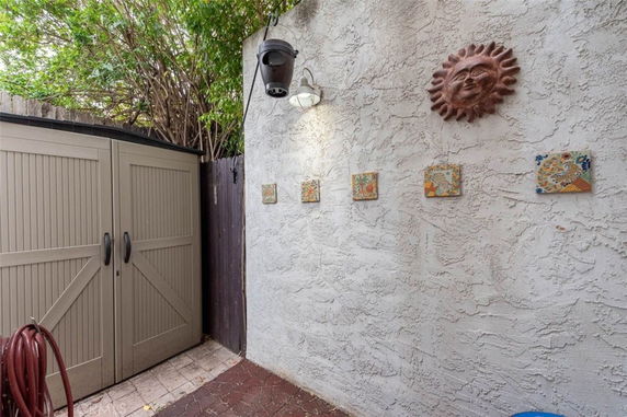 Outdoor storage area with textured wall and decorative tiles.