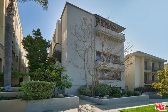 Front view of a multi-story residential building with balconies.
