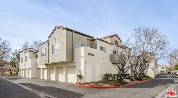 Front view of a multi-story apartment building with attached garages.