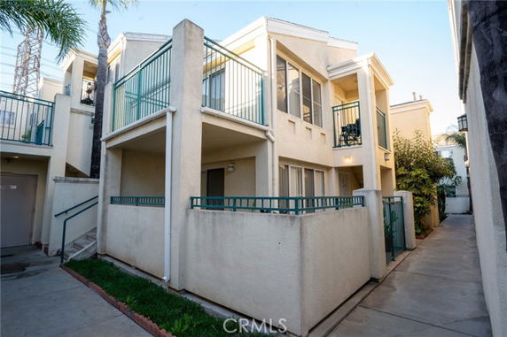 Front view of a two-story building with balconies and a gated entrance.