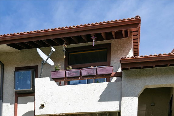 Front view of a building with a satellite dish and balcony.