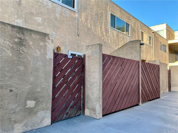 Front view of a building with a textured wall and wooden gate.