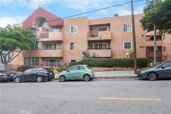 Front view of a multi-story apartment building with balconies.