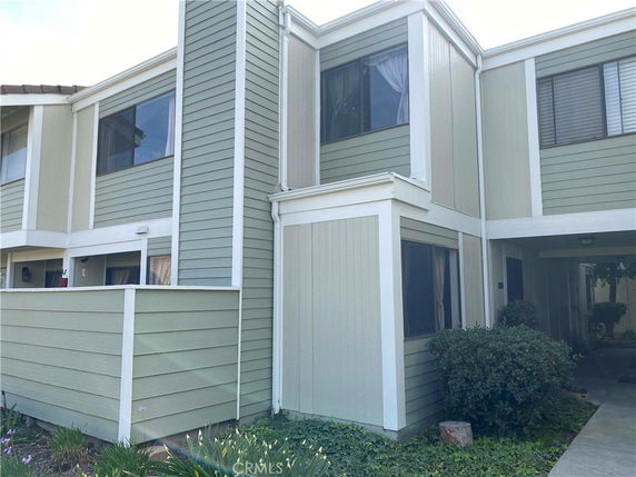 Front view of a two-story building with light green and white siding.
