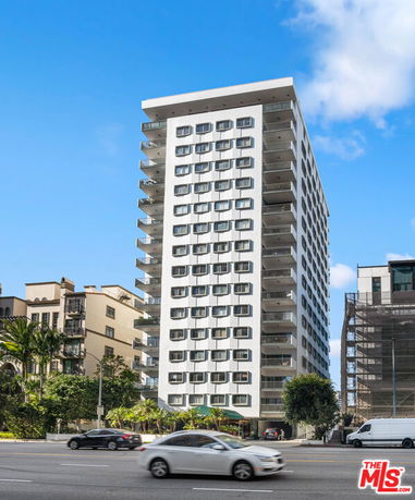 Front view of a high-rise apartment building with multiple balconies.
