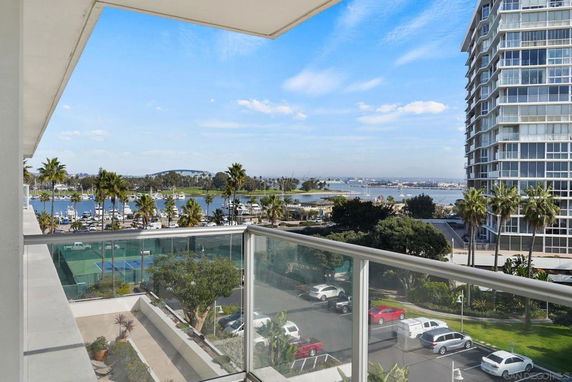 Elevated view of surroundings including water, tennis courts, and nearby buildings.