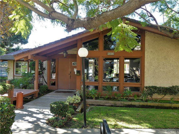 Front view of a single-story building with large windows and a wooden entrance.