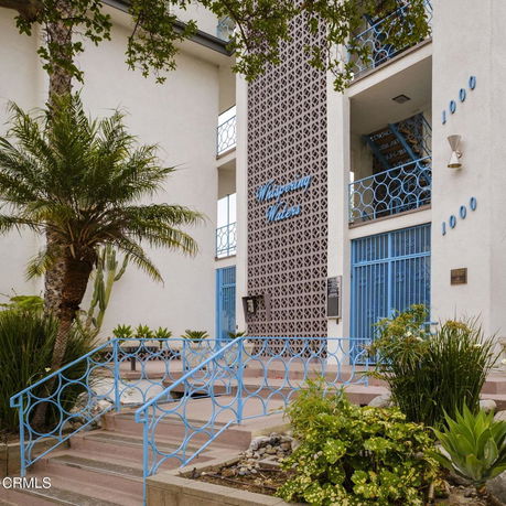 Front view of a building entrance with decorative metal railing and architectural design.