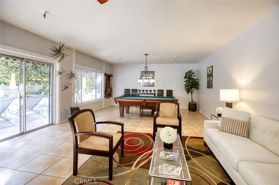 Indoor area featuring a pool table and seating with sliding glass doors leading outside.