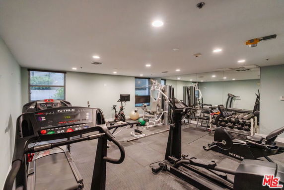 Indoor gym with various exercise equipment including treadmills and weight machines.