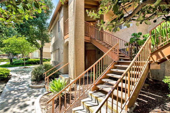 Front view of a two-story building with an outdoor staircase.
