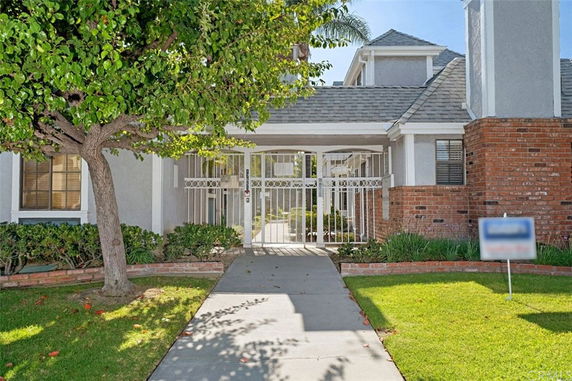 Front view of a house with gated entrance and brick accents.