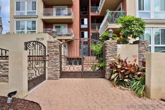 Front view of a multi-story building with balconies and decorative gate.